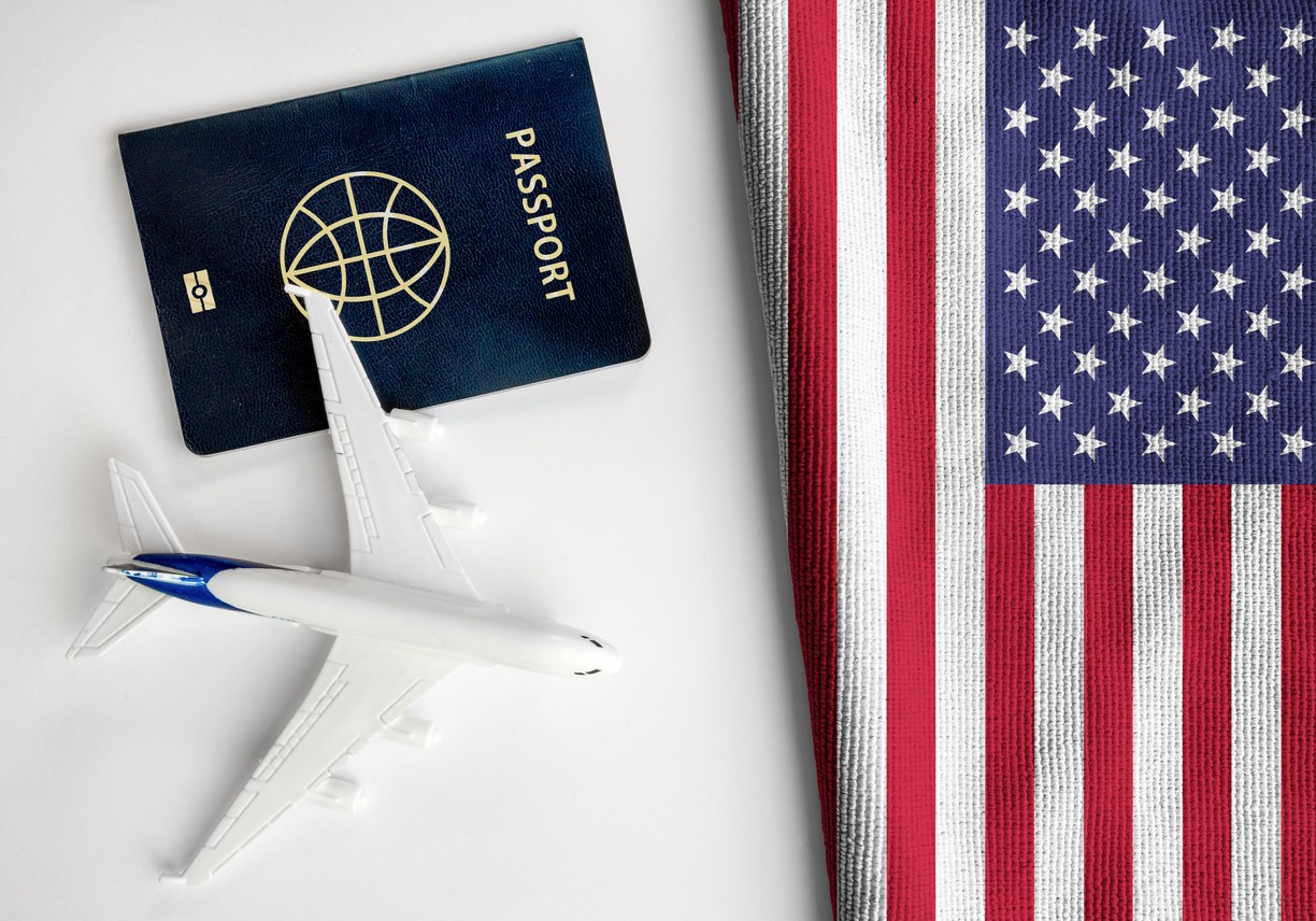 USA Passport next to the US flag and a little toy-airplane